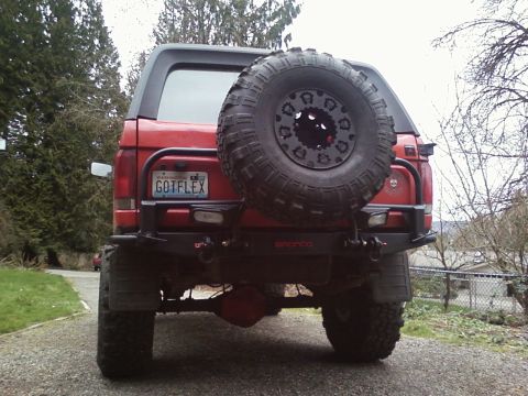 1989 Ford Bronco - Rear view of a red Ford Bronco showing its spare tire and custom bumper.