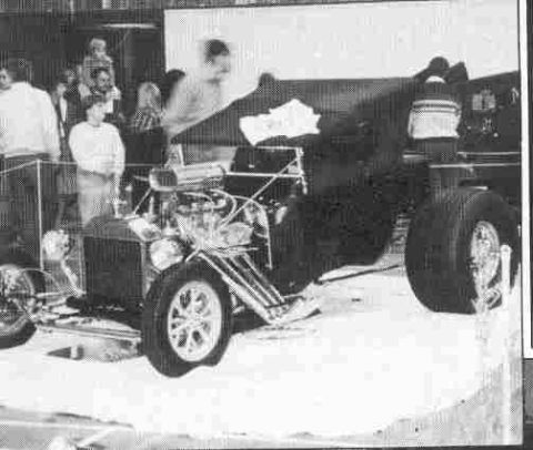 1969 Lincoln Continental - A custom-built dragster with a prominent engine and large rear wheels is displayed indoors.
