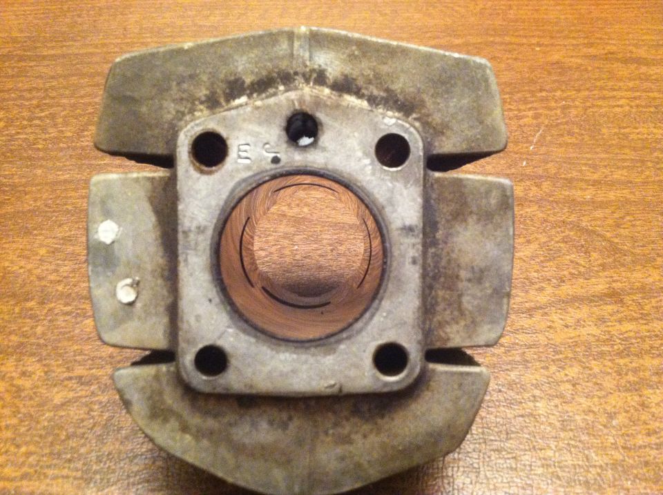 Motorcycle cylinder part with 'ES' marking, showing internal bore