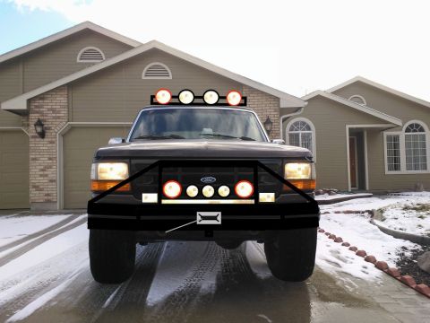 1992 Ford Bronco - This Ford truck features an aftermarket bumper with auxiliary lights and a light bar on the roof.