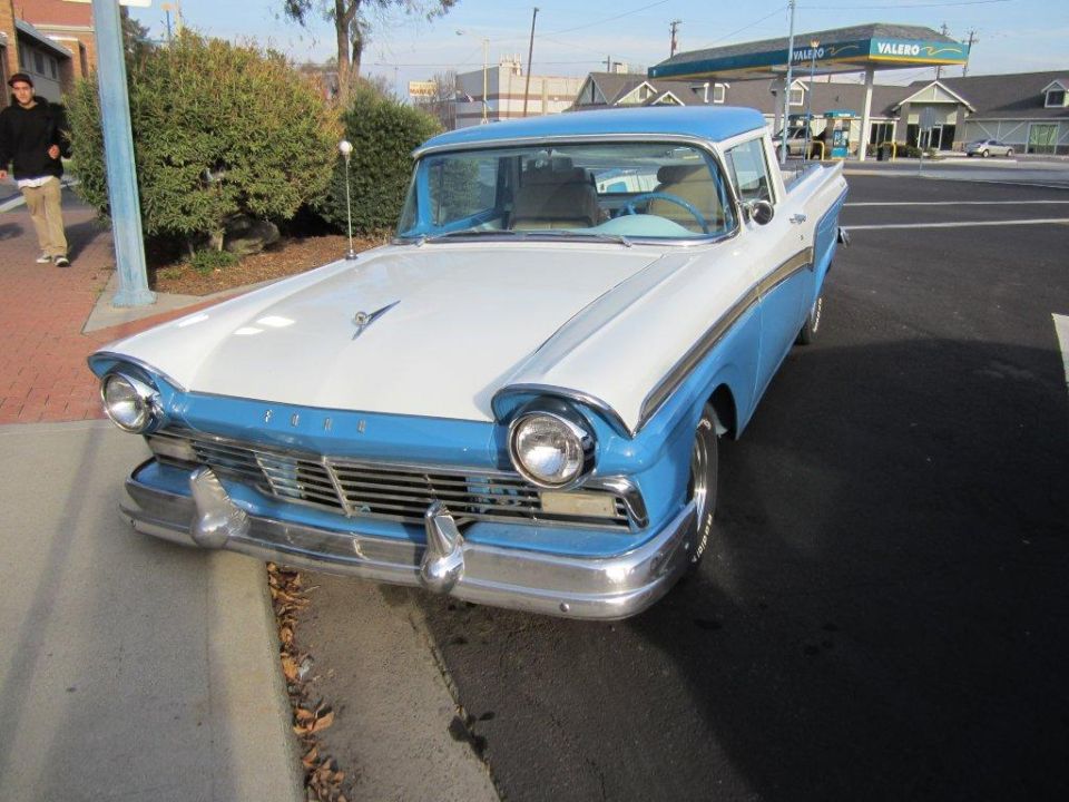 Blue and white 1957 Ford Ranchero parked on street, front view