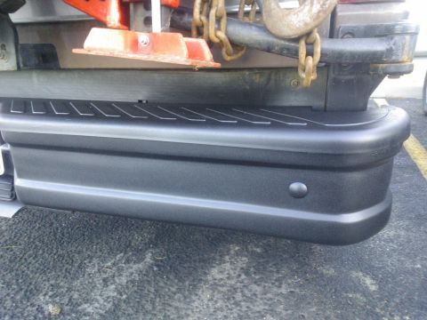1992 Ford Bronco - Close-up of a vehicle's rear bumper, showing a step and tow hitch chains.