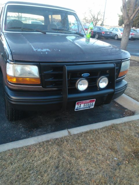 1992 Ford Bronco - This 1992 Ford Bronco is parked in a lot, showing its front grille and bumper with added lights.