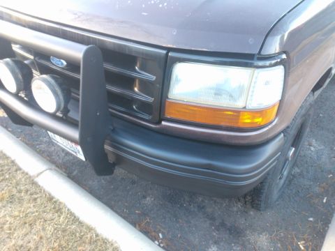 1992 Ford Bronco - Front view of a brown 1992 Ford Bronco, equipped with a bull bar and fog lights.
