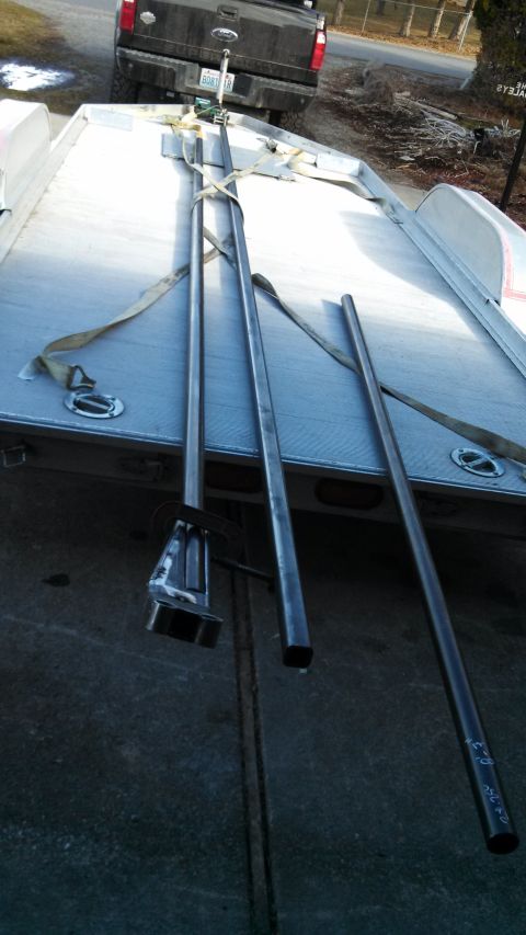1967 Ford F-250 - Metal poles secured to a trailer, with a black pickup truck visible behind it.