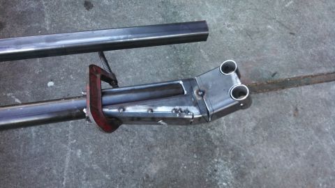 1967 Ford F-250 - A metal part is being welded and clamped, with additional metal stock nearby.