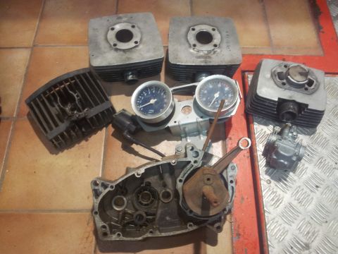1973 Ford Ranchero - Various disassembled motorcycle engine components are arranged on a tiled and metal surface.