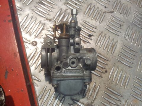 1973 Ford Ranchero - A single carburetor is shown against a textured metal background.