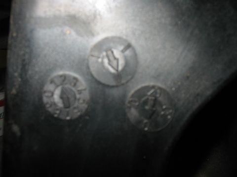 2003 Ford Crown Victoria - This image shows a metal component with three circular markings, one of which has visible numbers.
