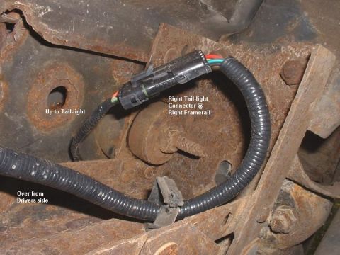 1986 Ford Bronco - Close-up view of a vehicle's right tail-light connector and wiring harness attached to the frame.
