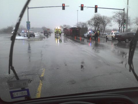 2003 Ford Crown Victoria - Emergency responders attend to a multi-vehicle accident on a wet roadway, involving an overturned truck and police vehicles.