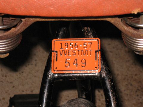 1994 Ford Bronco - A vintage motorcycle license plate shows registration details from 1956-57.