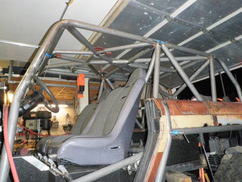 1961 International Scout 800 - Interior view of a vehicle's custom roll cage and seats, with a rusty door panel visible.