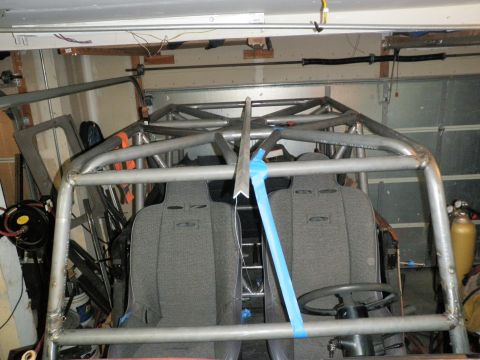 1961 International Scout 800 - Interior view of a custom roll cage and two grey bucket seats, likely for an off-road vehicle, in a garage setting.