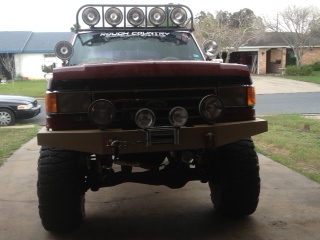 1990 Ford Bronco - Front view of a modified Ford Bronco with off-road lights and a custom bumper.