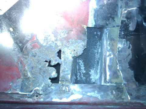 1978 Ford Bronco - Close-up of heavily corroded vehicle body panel, showing significant rust damage and structural compromise.