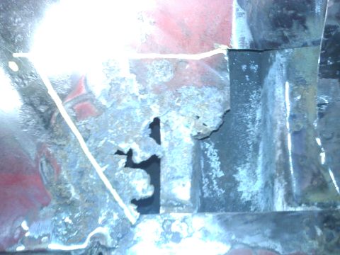 1978 Ford Bronco - Close-up view of a heavily rusted metal panel, showing significant corrosion and a hole.