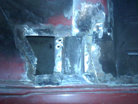 1978 Ford Bronco - This image shows a close-up view of heavily rusted metal, likely a vehicle part undergoing repair or showing significant wear.
