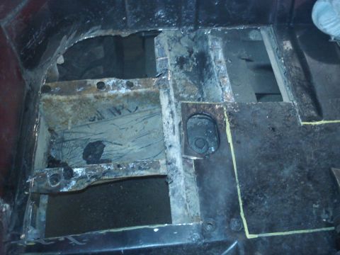 1978 Ford Bronco - Close-up view of a heavily rusted and damaged vehicle floor pan and frame structure.