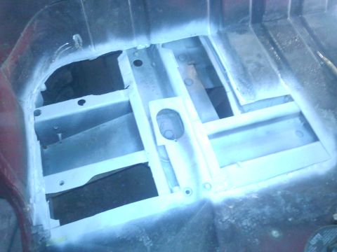 1978 Ford Bronco - Close-up view of the vehicle's interior frame structure, coated in white primer.