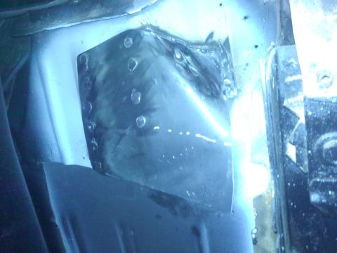 1978 Ford Bronco - A close-up view of a metal patch with rivets, likely a repair on a vehicle's undercarriage.