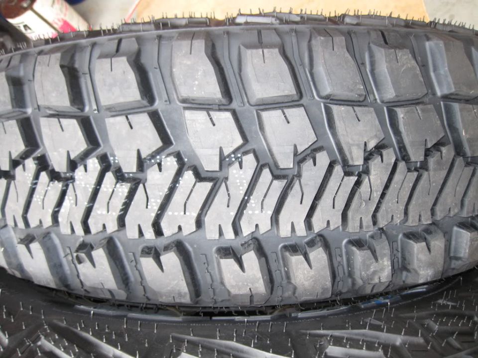 Close-up of a tire tread with aggressive blocky pattern and siping