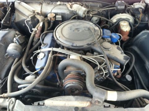 1970 Cadillac DeVille - The engine bay of a vehicle, various hoses, the air cleaner, and other engine components.