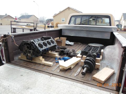 1979 Ford F-150 - Engine components are transported in the bed of a pickup truck.