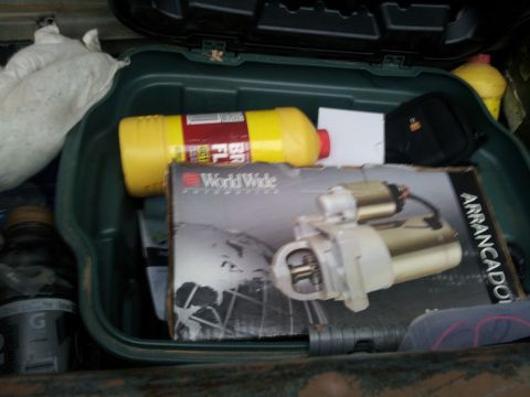 1986 Ford Bronco - A starter motor is visible inside a box, along with other items in a green container.