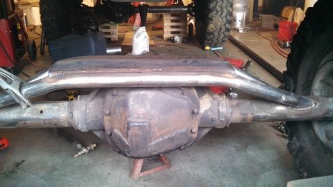 1967 Ford F-250 - Custom exhaust fabrication on a vehicle's rear axle assembly in a workshop setting.