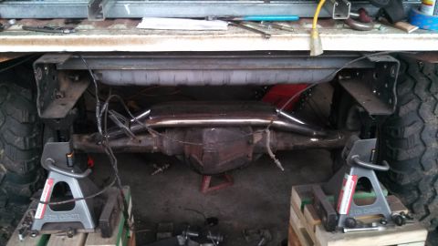 1967 Ford F-250 - Underbody view of a truck's rear axle and suspension system, with components supported by jack stands.
