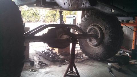1967 Ford F-250 - The rear axle assembly of a vehicle is shown, elevated on jack stands in a workshop setting.