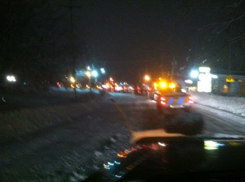1989 Ford Bronco - A snowy night scene shows a traffic jam with multiple vehicles and flashing lights.