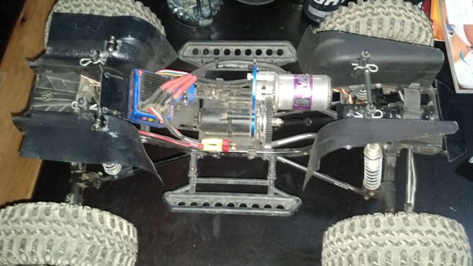 RC car chassis with motor, electronics, and suspension visible