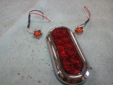 1995 Ford F-150 - Set of trailer lights including one large oval tail light and two smaller marker lights.