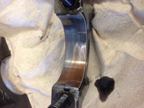 1966 Ford Bronco - This engine bearing shows signs of wear and rust, indicating potential maintenance issues.