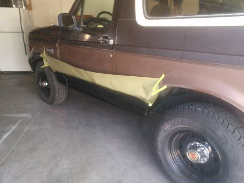 1992 Ford Bronco - Side view of a 1992 Ford Bronco with masking tape on the lower body panel.