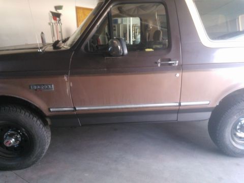 1992 Ford Bronco - This 1992 Ford Bronco is shown from the side, with its two-tone brown paint scheme and chrome trim.