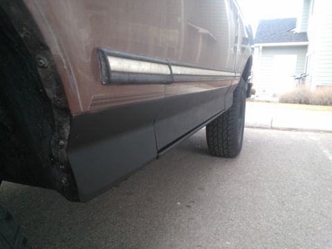 1992 Ford Bronco - The side of a brown SUV is shown, black lower trim and a white accent stripe above it.