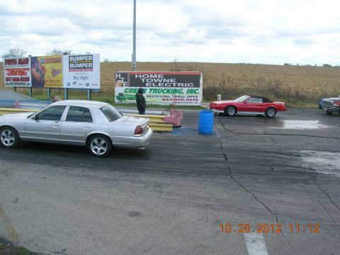 2003 Ford Crown Victoria - A silver 2003 Ford Crown Victoria is parked on the drag strip, with other vehicles visible in the background.