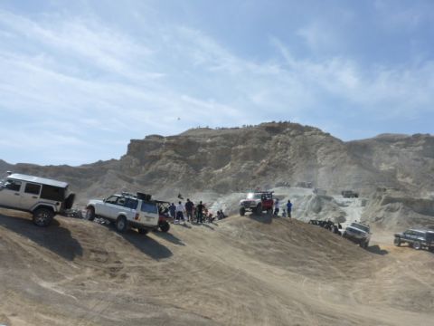 1997 Ford Ranger - Multiple off-road vehicles navigate a dusty, hilly terrain under a partly cloudy sky.