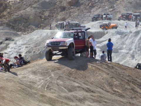 1997 Ford Ranger - Several off-road vehicles gather on a dusty, rocky terrain under a bright sky.