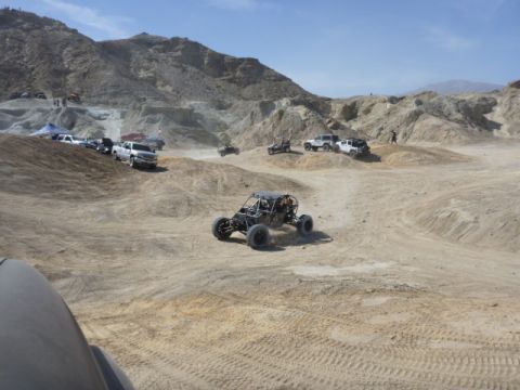 1997 Ford Ranger - Multiple off-road vehicles navigate a dusty desert terrain under a clear blue sky.