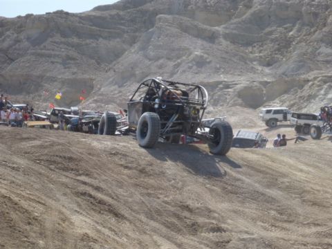 1997 Ford Ranger - Several off-road vehicles are gathered on a dusty, hilly terrain under a bright sky.