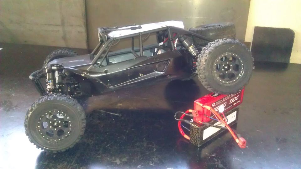 Radio-controlled rock crawler buggy with a red battery pack