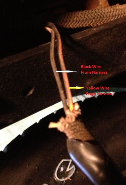 1978 Ford Bronco - Underbody photo with callouts identifying a black wire and a yellow wire coming from the harness, spliced to a pigtail near a frame rail.