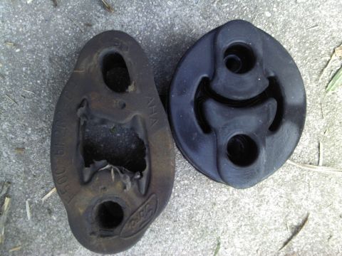 2000 Lincoln Continental - Comparison of a worn Ford exhaust hanger next to a new replacement part.