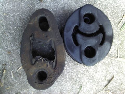 2000 Lincoln Continental - Comparison of a worn-out exhaust hanger with a new one, showing the Ford logo on the older part.