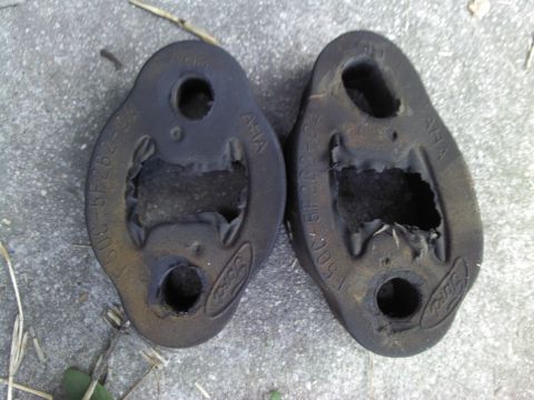 2000 Lincoln Continental - Worn rubber exhaust hangers, likely from a Ford vehicle, show signs of significant wear and tear.
