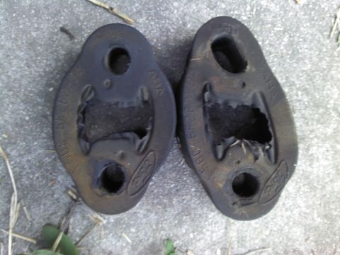 2000 Lincoln Continental - Worn rubber exhaust hangers with Ford logos and part numbers are shown on the ground.